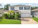 Charming two-story home featuring a well-maintained lawn, tropical landscaping, and a two-car garage at 8305 Praise Dr, Tampa, FL 33625