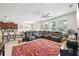 Spacious living room showcasing a sectional sofa, a vibrant rug, and seamless flow to the kitchen at 8305 Praise Dr, Tampa, FL 33625