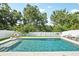 Sparkling in-ground pool surrounded by white fencing and lush landscaping, perfect for relaxation and entertaining at 8305 Praise Dr, Tampa, FL 33625