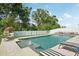 A gorgeous backyard pool with sun loungers, an egg chair, and a pristine white fence at 8305 Praise Dr, Tampa, FL 33625