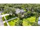 Aerial view of a home with mature trees, manicured lawn, fenced backyard, and paver driveway at 8901 Eagle Watch Dr, Riverview, FL 33578