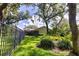 Backyard with mature trees, lush landscaping, and a glimpse of the screened-in lanai at 8901 Eagle Watch Dr, Riverview, FL 33578