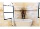Bright bathroom features a standalone tub, beautiful travertine tile and accent mosaic detail at 8901 Eagle Watch Dr, Riverview, FL 33578