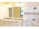 Well-lit bathroom featuring double sinks, granite countertops, and travertine tiled shower at 8901 Eagle Watch Dr, Riverview, FL 33578