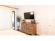 Bedroom with dresser, TV, hardwood floors, and sliding door to the balcony with a view at 8901 Eagle Watch Dr, Riverview, FL 33578