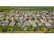 Gorgeous aerial view of a home with a private screened in pool and lush green trees in a well-maintained community at 9275 Bella Vita Cir, Land O Lakes, FL 34637