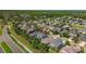 Beautiful aerial view of a home with mature landscaping in a well-maintained community with lush trees in the background at 9275 Bella Vita Cir, Land O Lakes, FL 34637