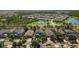 Neighborhood aerial view of homes surrounded by trees and a pond at 9275 Bella Vita Cir, Land O Lakes, FL 34637