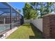 Green backyard with a white privacy fence and a screened in patio with a pool at 9275 Bella Vita Cir, Land O Lakes, FL 34637