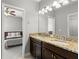 Bathroom with dual sinks, granite countertops, and vanity with a view of the bedroom at 9275 Bella Vita Cir, Land O Lakes, FL 34637
