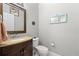 Charming half bathroom featuring a wood vanity with granite counters, decorative wall art and a mirror at 9275 Bella Vita Cir, Land O Lakes, FL 34637