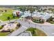 Stunning aerial view of the community clubhouse featuring a pool, green space, palm trees, and lovely architecture at 9275 Bella Vita Cir, Land O Lakes, FL 34637