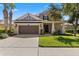 Charming home with a well-manicured lawn, a welcoming entrance, and a two-car garage at 9275 Bella Vita Cir, Land O Lakes, FL 34637