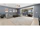 Spacious living room with a sectional sofa, a rug, and sliding doors to the outdoor pool area at 9275 Bella Vita Cir, Land O Lakes, FL 34637