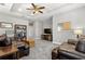 Comfortable living room with tray ceiling, ceiling fan, plush carpet, and leather furniture at 9275 Bella Vita Cir, Land O Lakes, FL 34637