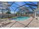 Inviting screened-in pool area with outdoor lighting and lush landscaping at 9275 Bella Vita Cir, Land O Lakes, FL 34637