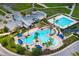 Amazing aerial view of a community pool with a slide, splash pad, lap pool, lounge chairs, and covered seating at 9275 Bella Vita Cir, Land O Lakes, FL 34637