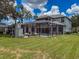 Large backyard features a screen-enclosed pool, outdoor kitchen, and fireplace at 9808 Milano Dr, Trinity, FL 34655