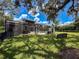 This backyard features a screen-enclosed pool, outdoor kitchen, and outdoor fireplace at 9808 Milano Dr, Trinity, FL 34655