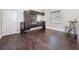 Well-equipped bar area with custom cabinetry, wood floors, and modern bar table with stools at 9808 Milano Dr, Trinity, FL 34655
