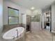 Bright bathroom featuring a glass shower, soaking tub, and mosaic tile accents at 9808 Milano Dr, Trinity, FL 34655