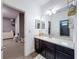 Stylish bathroom features a dark vanity and sink, with a view to the hall and second bathroom at 9808 Milano Dr, Trinity, FL 34655