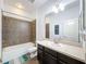 Bathroom with updated vanity, shower-tub combo, tiled flooring, and large mirror at 9808 Milano Dr, Trinity, FL 34655