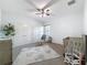 Cozy bedroom featuring a crib, rocker, and dresser with a soft rug on carpeted floors at 9808 Milano Dr, Trinity, FL 34655