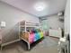 Neutral bedroom with a bunk bed, white dresser, and patterned rug under a modern light fixture at 9808 Milano Dr, Trinity, FL 34655