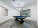 Large game room featuring a stylish chandelier, pool table, and tile flooring with a view at 9808 Milano Dr, Trinity, FL 34655