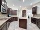Modern kitchen with granite countertops, stainless appliances, tile backsplash, and a large island at 9808 Milano Dr, Trinity, FL 34655