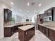 Spacious kitchen features an island, stainless appliances, granite countertops, and dark wood cabinetry at 9808 Milano Dr, Trinity, FL 34655