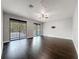 Spacious living room with dark hardwood floors, a ceiling fan, and sliding doors to the outside at 9808 Milano Dr, Trinity, FL 34655
