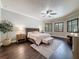 A primary bedroom with dark floors, two windows with shutters, neutral paint, and modern furnishings at 9808 Milano Dr, Trinity, FL 34655