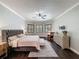 Comfortable primary bedroom featuring dark floors, shutters, and modern decor at 9808 Milano Dr, Trinity, FL 34655
