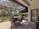 A covered outdoor kitchen includes a grill, refrigerator, sink, and plenty of counter space at 9808 Milano Dr, Trinity, FL 34655