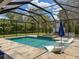 Screened-in pool and patio area with lounge chairs and landscaped surroundings at 9808 Milano Dr, Trinity, FL 34655