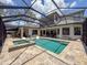 Screened-in pool and patio area with lounge chairs and landscaped surroundings at 9808 Milano Dr, Trinity, FL 34655
