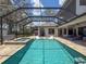 Enjoy the sparkling pool and spa surrounded by a screened enclosure and travertine tile deck at 9808 Milano Dr, Trinity, FL 34655