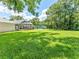 Large, green backyard features a tennis court and screened in porch in a lovely setting at 13710 Westshire Dr, Tampa, FL 33618