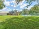 A lush backyard features a screened lanai and tennis court for outdoor enjoyment at 13710 Westshire Dr, Tampa, FL 33618