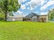 Expansive backyard view featuring a well-manicured lawn, a pool enclosure, and a tennis court at 13710 Westshire Dr, Tampa, FL 33618