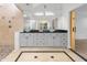 Bathroom with dual vessel sinks, granite counters, tile floor and barn door access to shower at 13710 Westshire Dr, Tampa, FL 33618