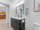 An updated bathroom with a modern vanity, hardware and lighting and stylish flooring at 13710 Westshire Dr, Tampa, FL 33618