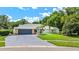Charming single-story home featuring a two-car garage, lush landscaping, and a well-manicured lawn at 13710 Westshire Dr, Tampa, FL 33618