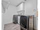Spacious laundry room with washer, dryer, sink and overhead cabinets at 13710 Westshire Dr, Tampa, FL 33618