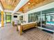 Covered patio with wood ceiling, stylish seating, and a glimpse of the inviting pool at 13710 Westshire Dr, Tampa, FL 33618