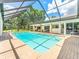 Sparkling pool surrounded by brick pavers and a screened enclosure with lush greenery at 13710 Westshire Dr, Tampa, FL 33618