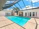 Large swimming pool surrounded by brick pavers and screened enclosure; a true backyard paradise at 13710 Westshire Dr, Tampa, FL 33618