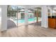 Indoor pool view from the living area, showcasing seamless indoor-outdoor living at 13710 Westshire Dr, Tampa, FL 33618